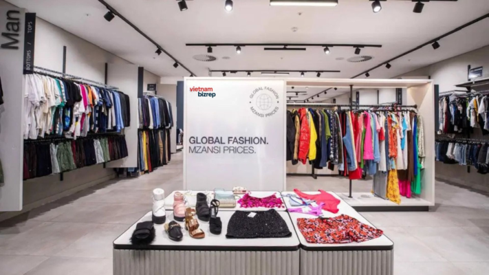 The owner of a fashion brand proudly displays a coat manufactured in Vietnam in their retail store